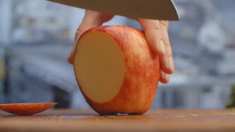 Cut-a-knife-on-a-wooden-board-closeup-red-apple-in-the-kitchen.-shred